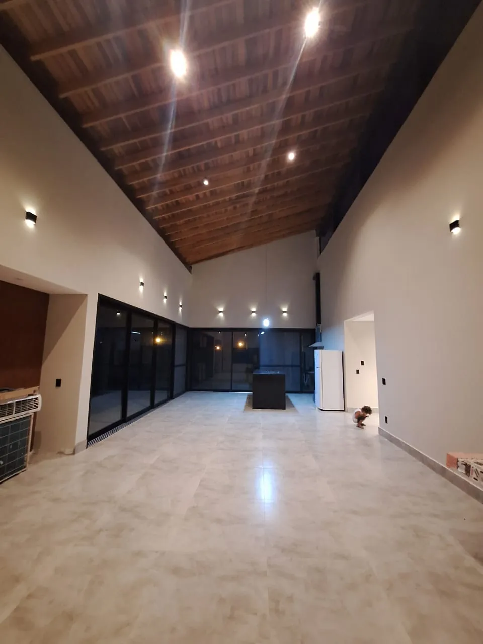Interior com pé-direito alto e forro em madeira, obra da A&R