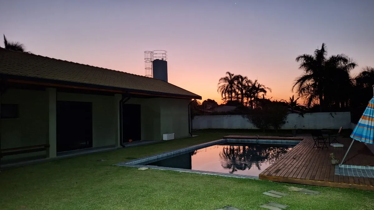 Área de piscina ao pôr do sol em residência entregue